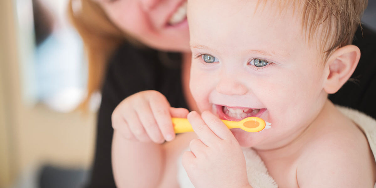 Parent brushing infant's teeth